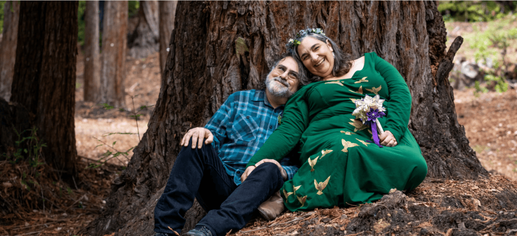 kathryn and joey sitting under their memorial tree after forest wedding